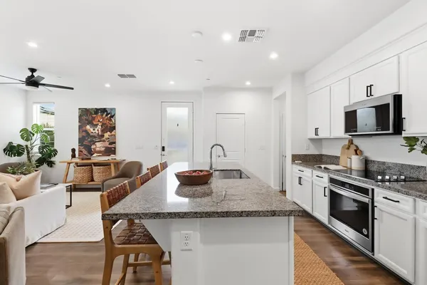 a kitchen with stainless steel appliances granite countertop a sink and cabinets