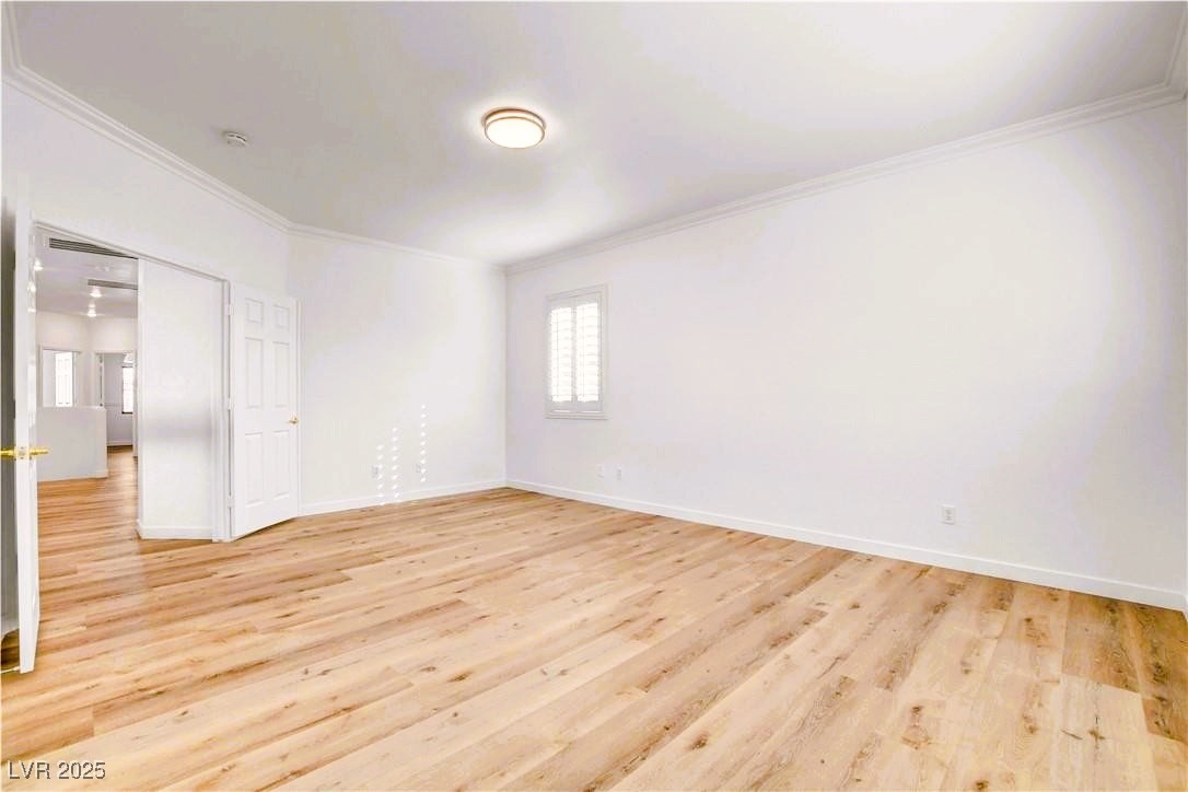 10247 Splendor Ridge Avenue Las Vegas, NV 89135 - Photo 14 of 38 Unfurnished room featuring ornamental molding and light wood-style flooring