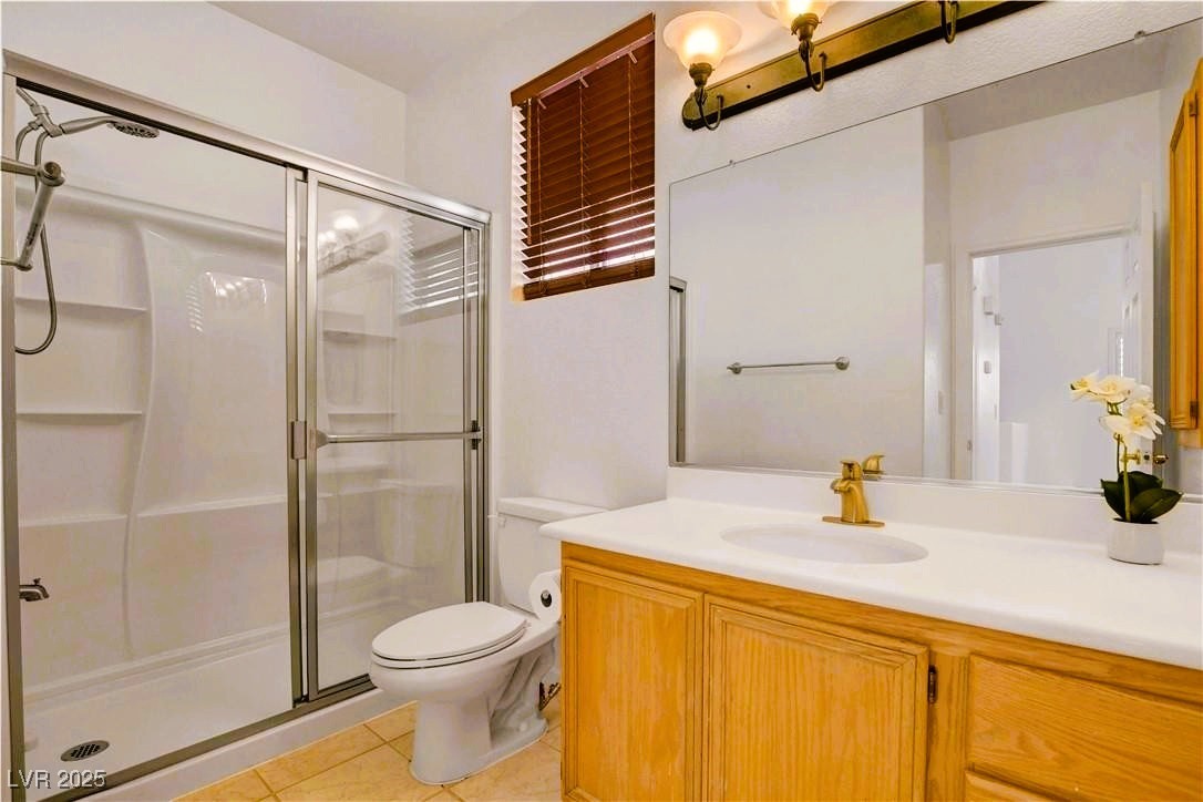 10247 Splendor Ridge Avenue Las Vegas, NV 89135 - Photo 29 of 38 Full bath featuring a shower stall, light tile patterned flooring, and vanity