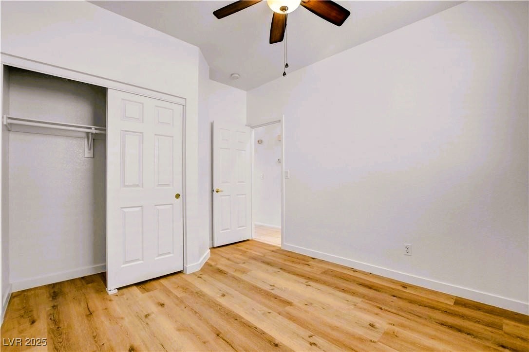 10247 Splendor Ridge Avenue Las Vegas, NV 89135 - Photo 30 of 38 Unfurnished bedroom featuring a closet, a ceiling fan, and light wood finished floors