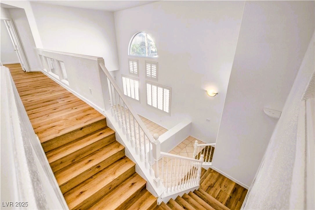 10247 Splendor Ridge Avenue Las Vegas, NV 89135 - Photo 6 of 38 Staircase featuring wood finished floors and a high ceiling