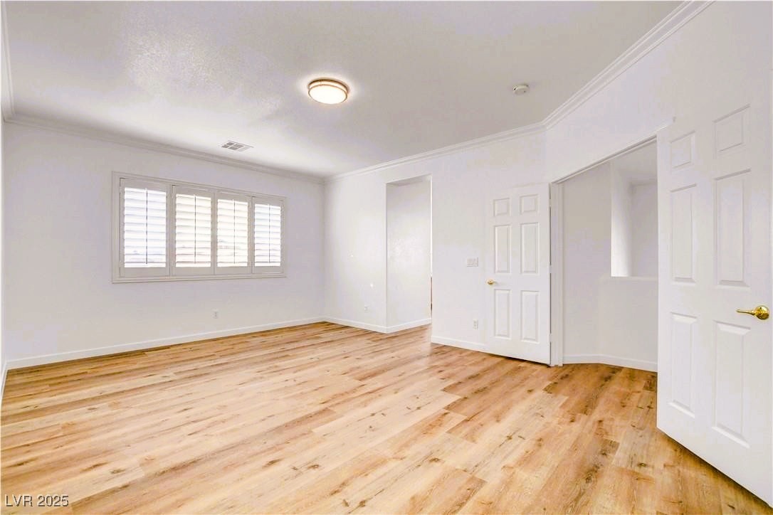 10247 Splendor Ridge Avenue Las Vegas, NV 89135 - Photo 9 of 38 Unfurnished room featuring crown molding and light wood-style flooring