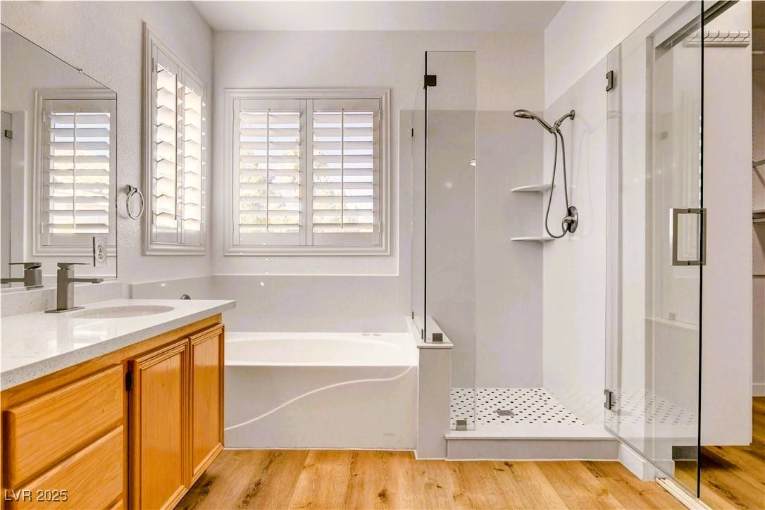 10247 Splendor Ridge Avenue Las Vegas, NV 89135 - Photo 10 of 38 Full bath featuring vanity, a garden tub, light wood finished floors, and a stall shower