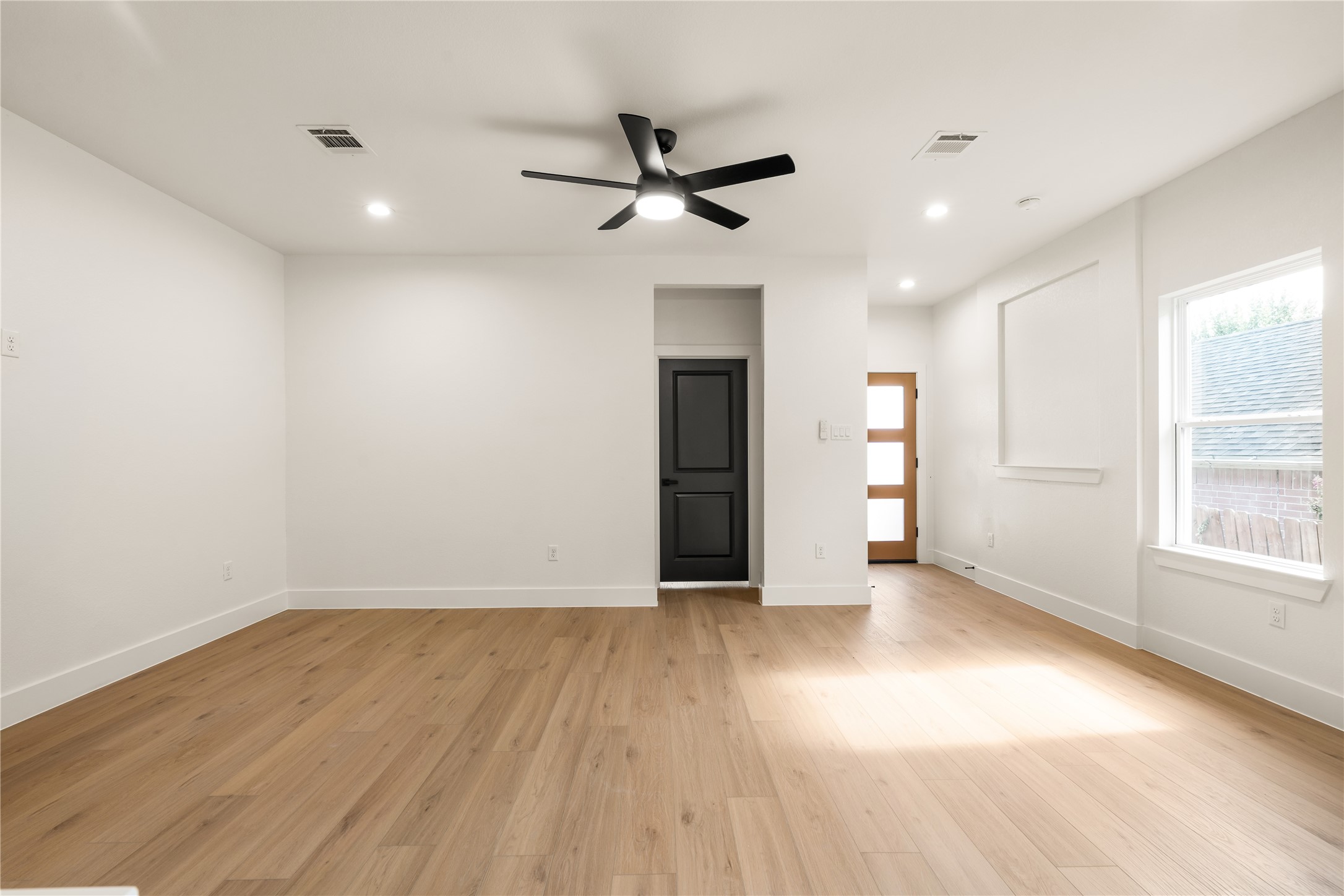 5321 Rue Street Houston, TX 77033 - Photo 5 of 23 Light and airy main level — recessed lighting throughout, private entryway view, and natural light pouring in from the side window.