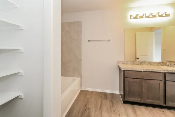 a bathroom with a granite countertop sink a mirror and a bathtub