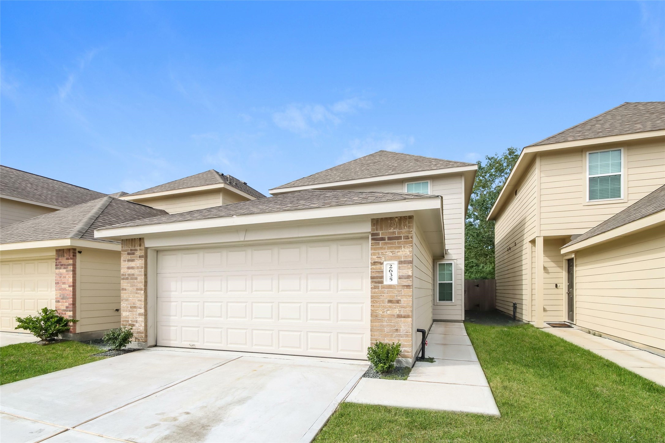 2635 Bouvardia Way Houston, TX 77073 - Photo 2 of 16 a front view of a house with a yard and garage