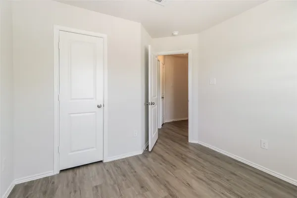 an empty room with wooden floor & closet