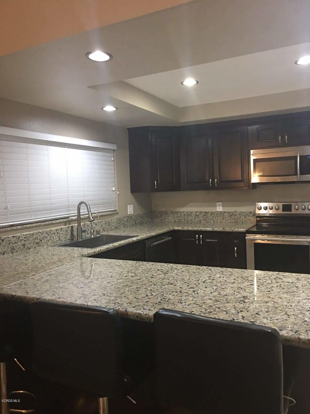 2050 North Riverside Avenue Rialto, CA 92377 - Photo 5 of 18 a kitchen with granite countertop a sink and a stove top oven