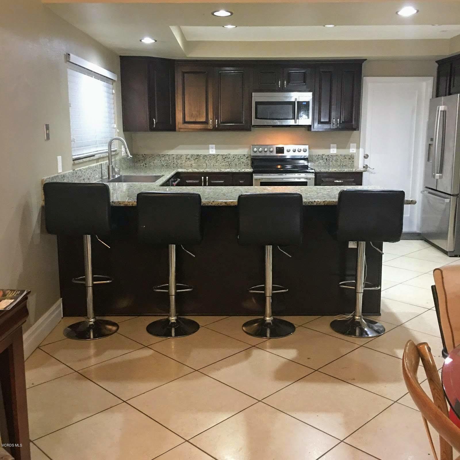 2050 North Riverside Avenue Rialto, CA 92377 - Photo 8 of 18 a kitchen with kitchen island granite countertop a sink and a stove