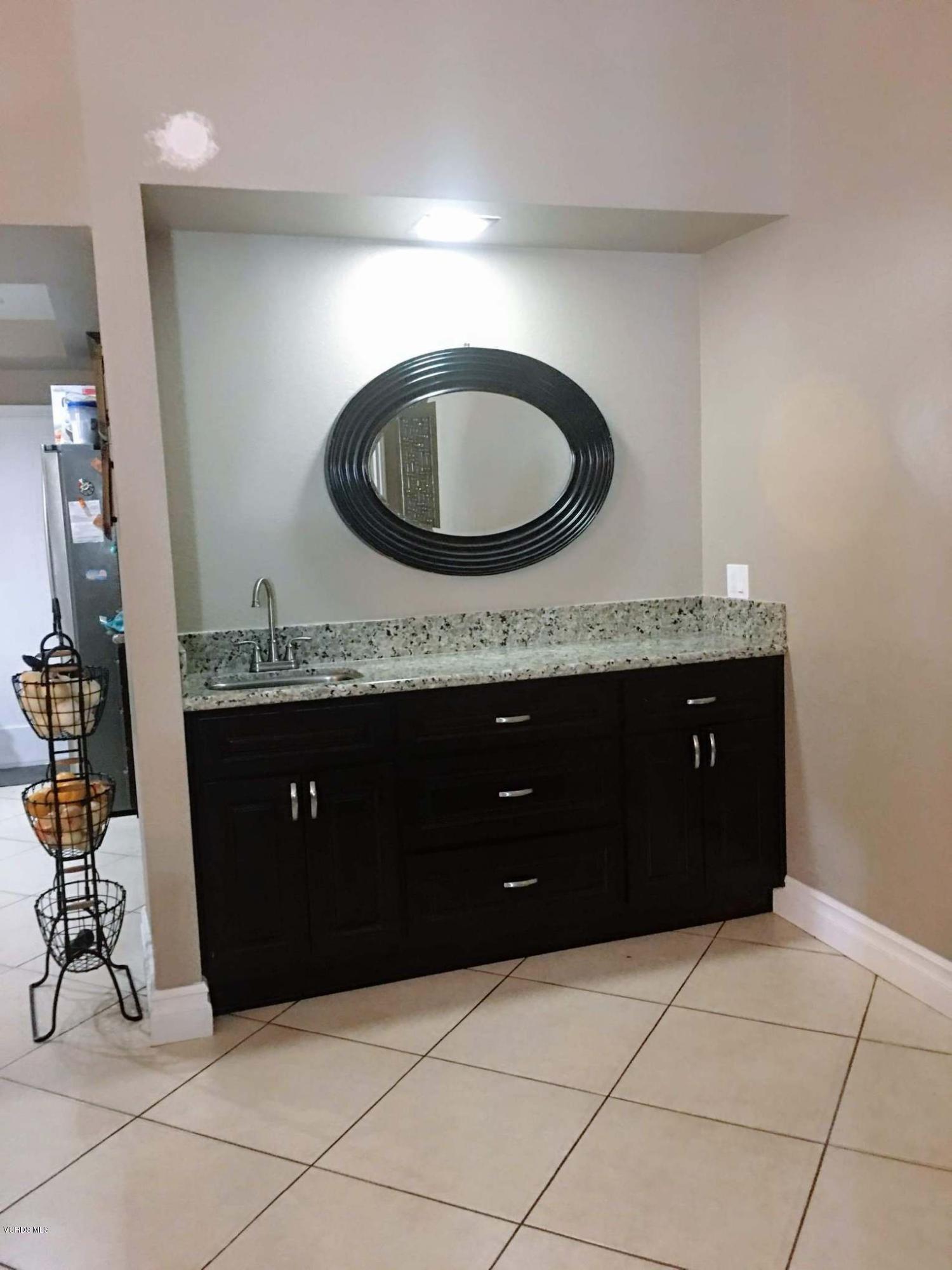 2050 North Riverside Avenue Rialto, CA 92377 - Photo 9 of 18 a bathroom with a granite countertop sink a vanity and a mirror