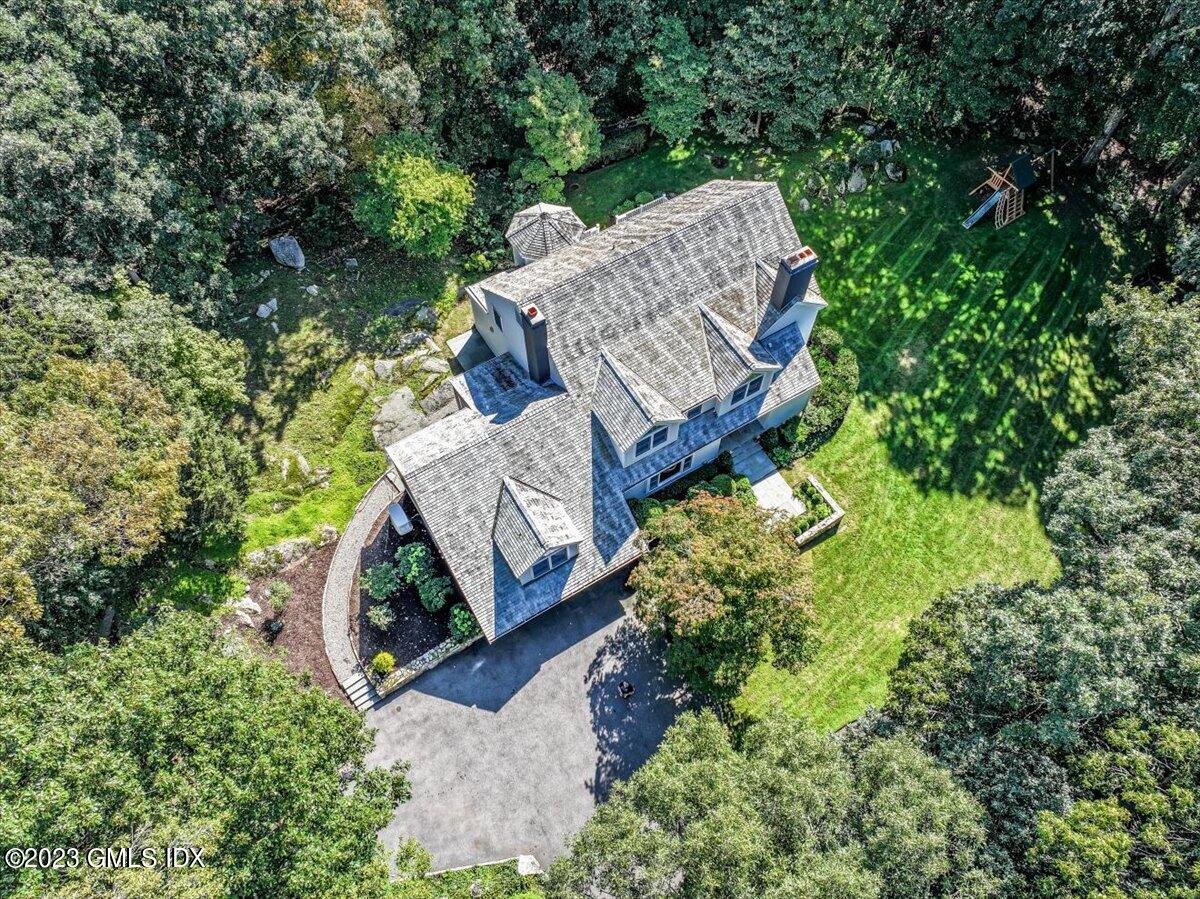 an aerial view of a house with garden space and sitting area