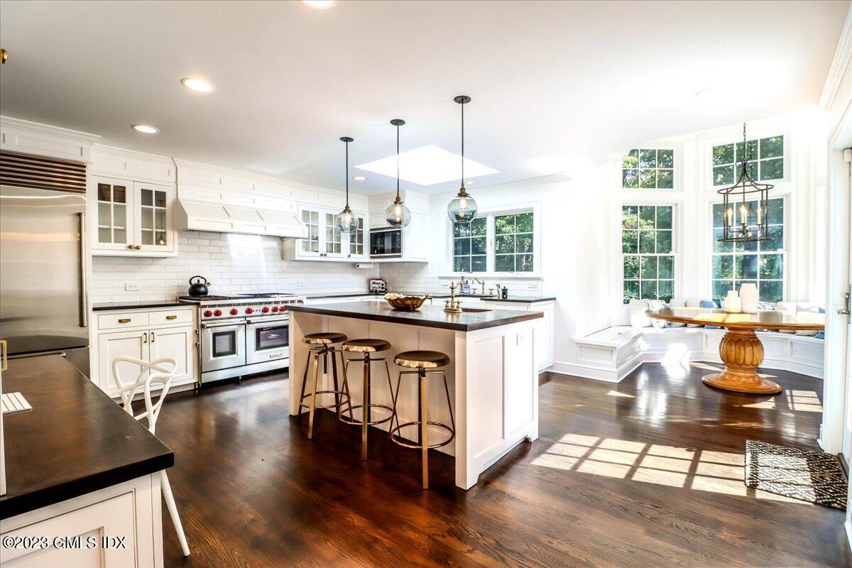 62 North Old Stone Bridge Road Cos Cob, CT 06807 - Photo 6 of 32 a kitchen with stainless steel appliances granite countertop a stove a sink a refrigerator and white cabinets with wooden floor