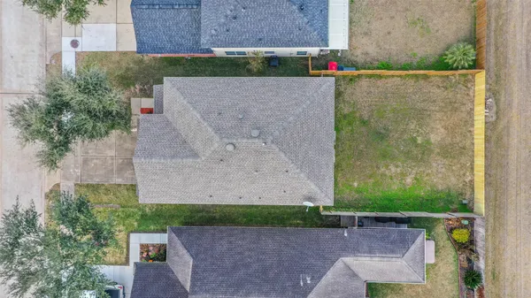 an aerial view of a house with a yard and a large tree