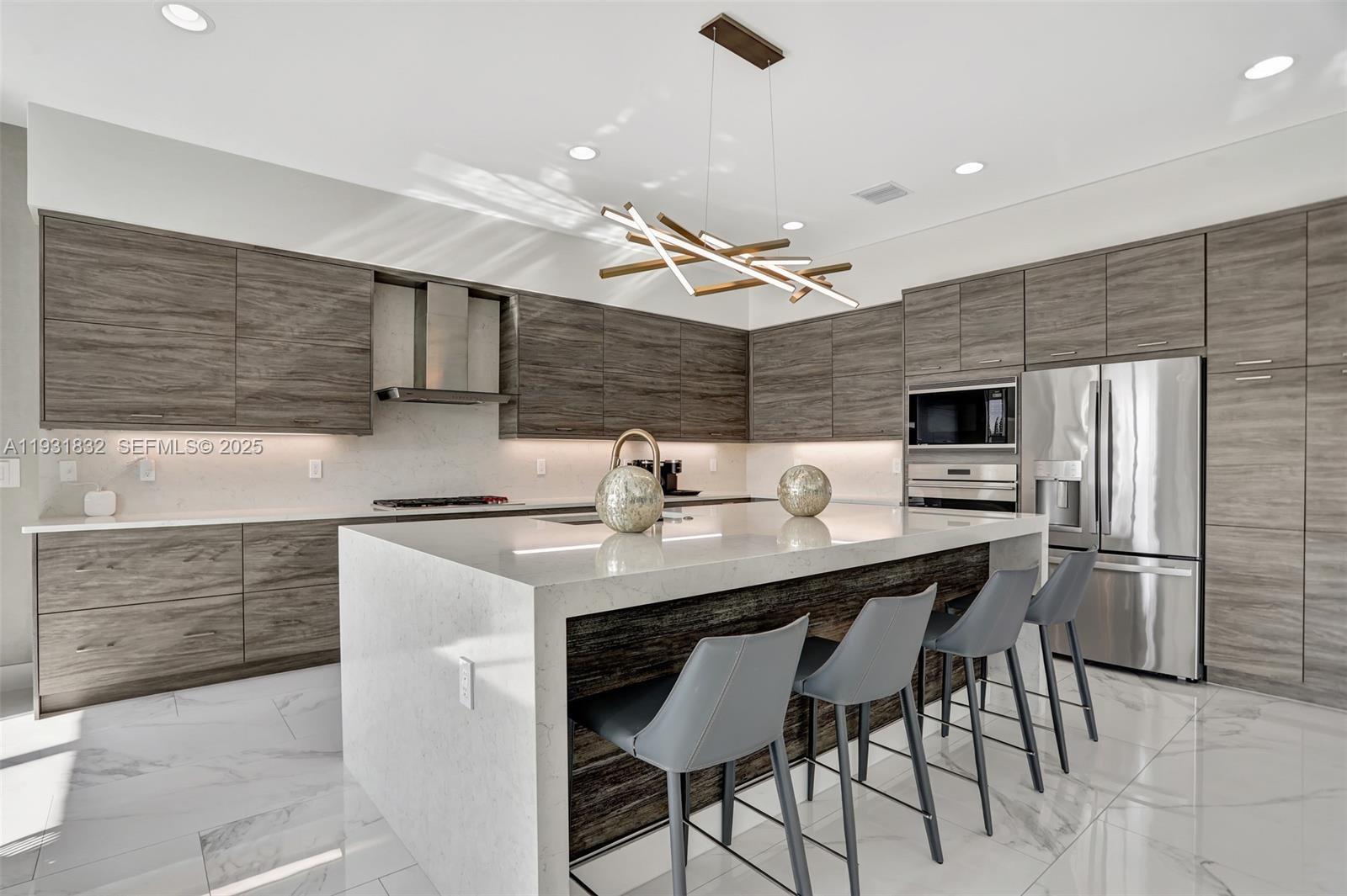 17113 Aquavera Way Boca Raton, FL 33496 - Photo 22 of 84 a kitchen with stainless steel appliances a sink a stove a refrigerator cabinets and chairs