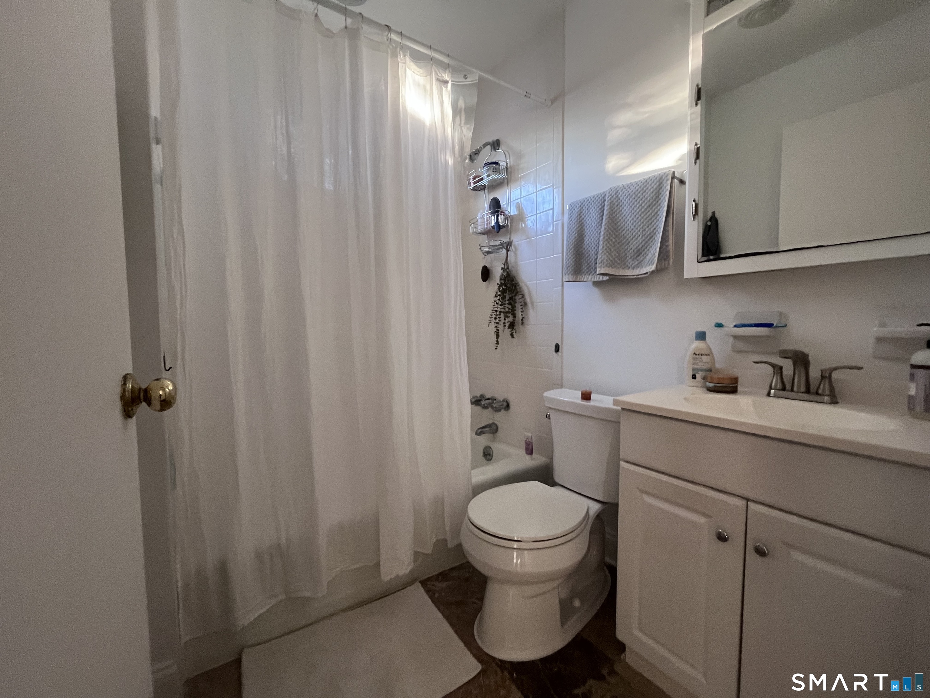 124 Thorpe Street Fairfield, CT 06824 - Photo 17 of 23 a bathroom with a toilet sink vanity and mirror