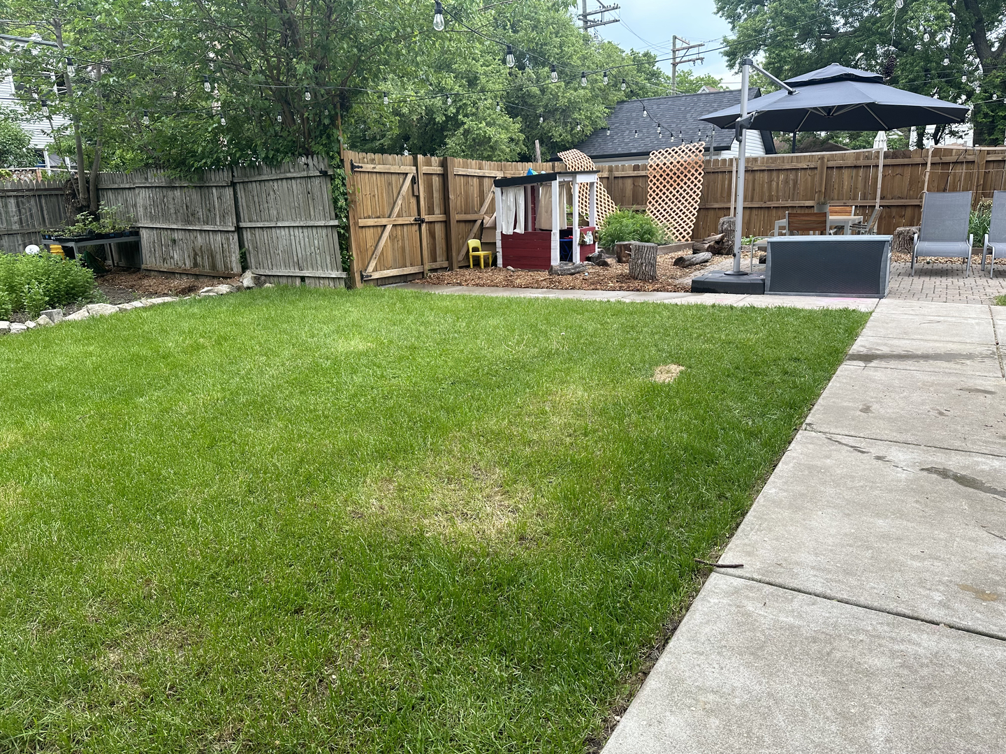 3428 West Belden Avenue, Unit 1 Chicago, IL 60647 - Photo 17 of 19 a view of a backyard with table and chairs under an umbrella