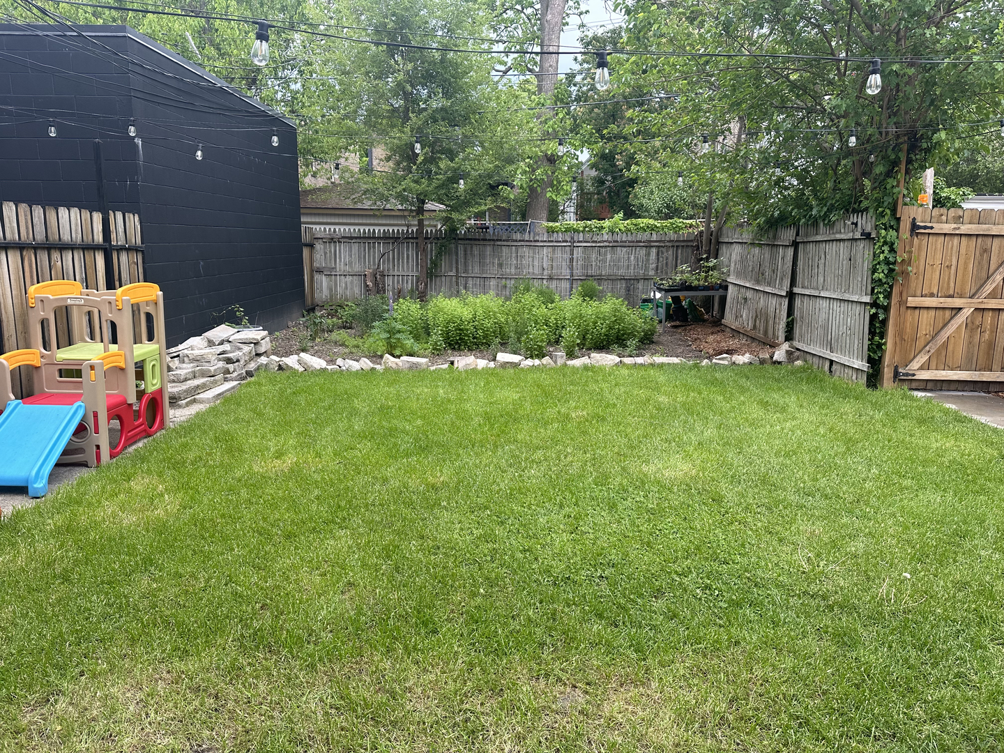 3428 West Belden Avenue, Unit 1 Chicago, IL 60647 - Photo 19 of 19 a backyard of a house with table and chairs plants and large tree