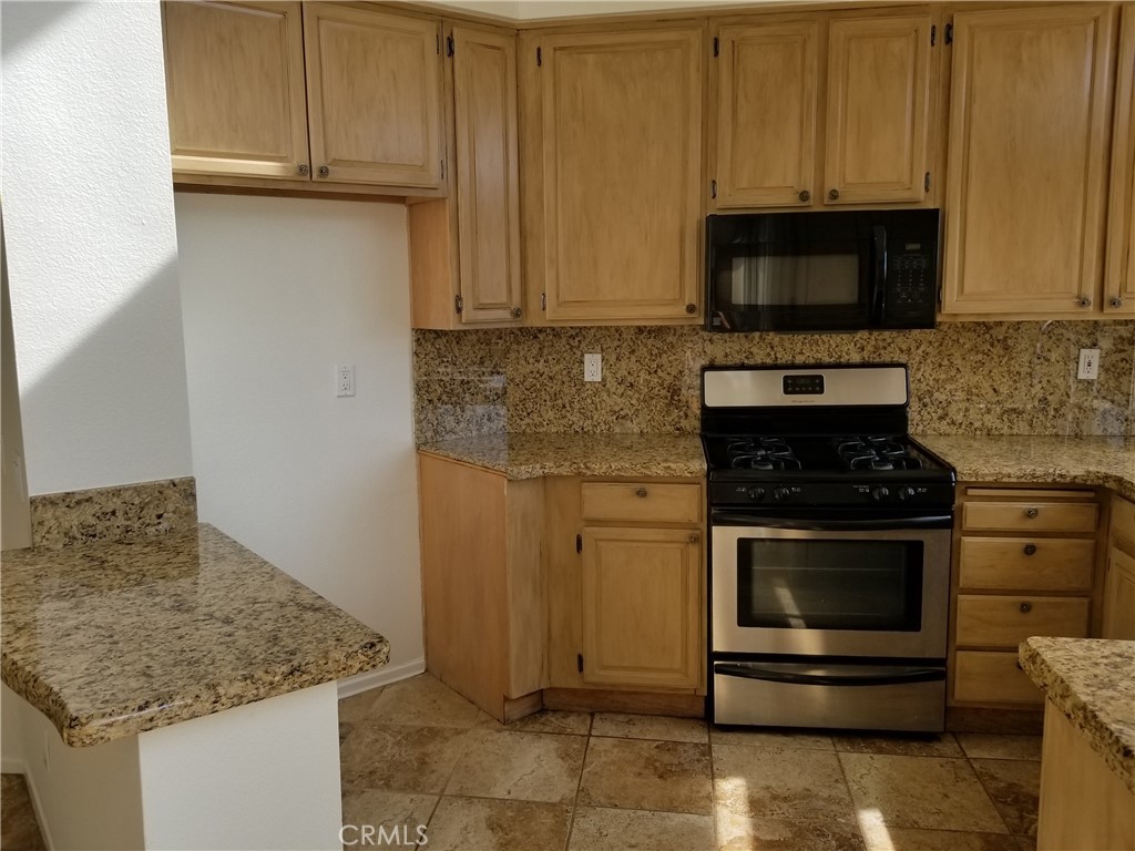 28225 Via Fierro Laguna Niguel, CA 92677 - Photo 17 of 70 a kitchen with stainless steel appliances granite countertop a stove a microwave and a sink
