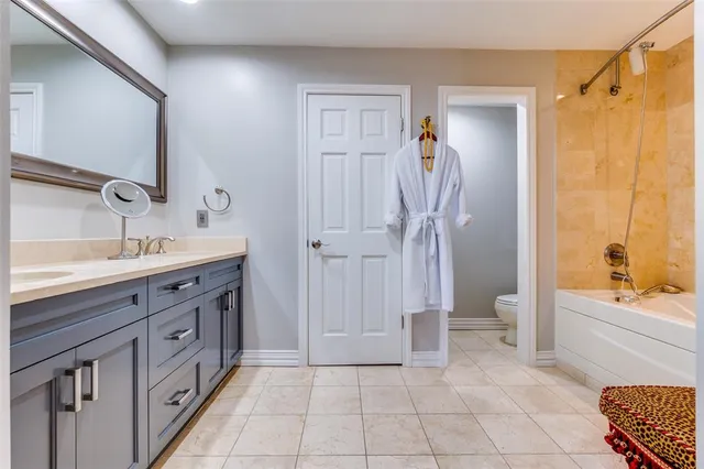 a bathroom with a double vanity sink a toilet and shower
