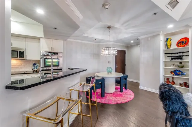 a kitchen with stainless steel appliances kitchen island granite countertop a stove a refrigerator and a dining table with wooden floor