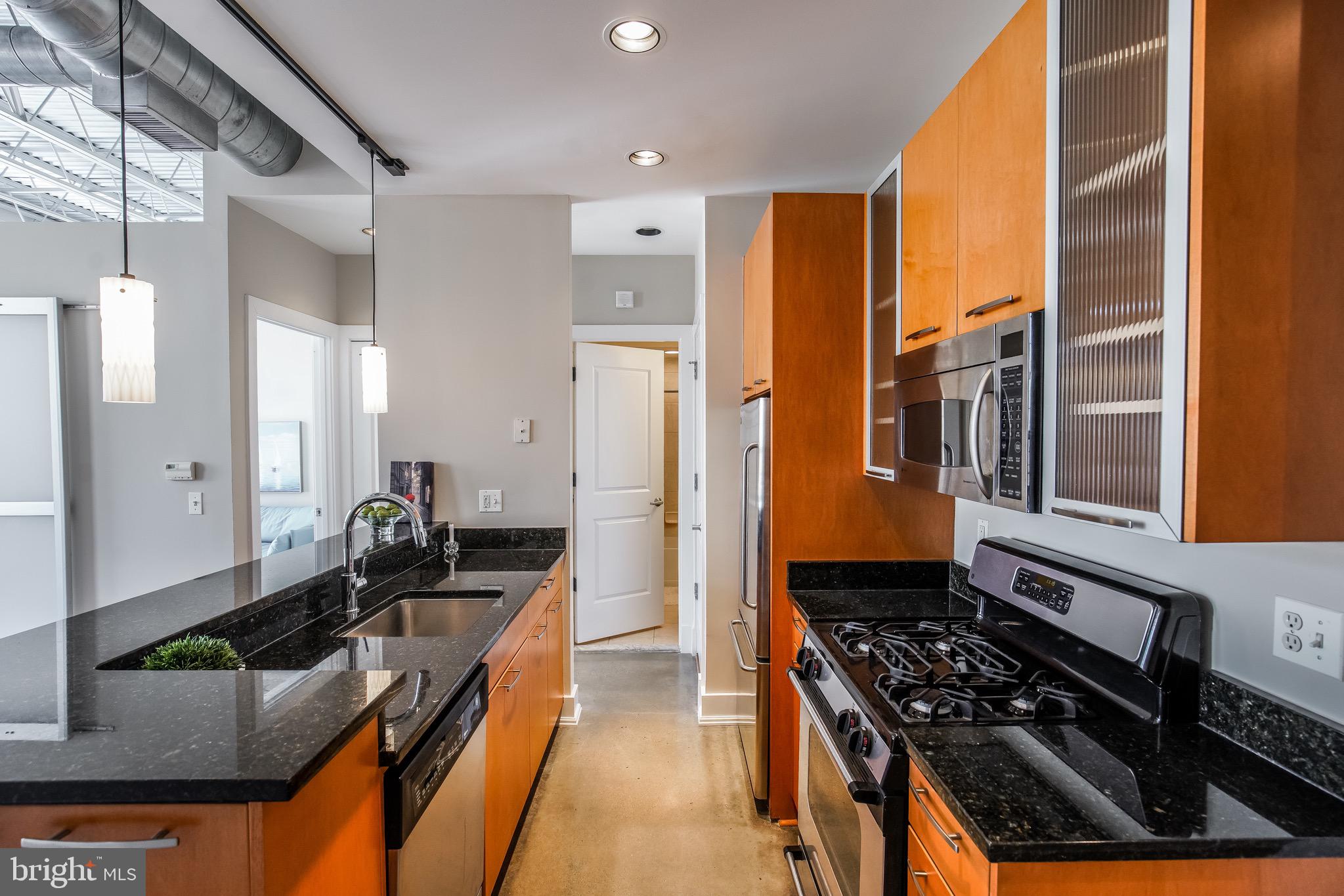 2421 18th Street Northwest, Unit 302 Washington, DC 20009 - Photo 4 of 30 a kitchen with stainless steel appliances granite countertop a stove a sink and a refrigerator