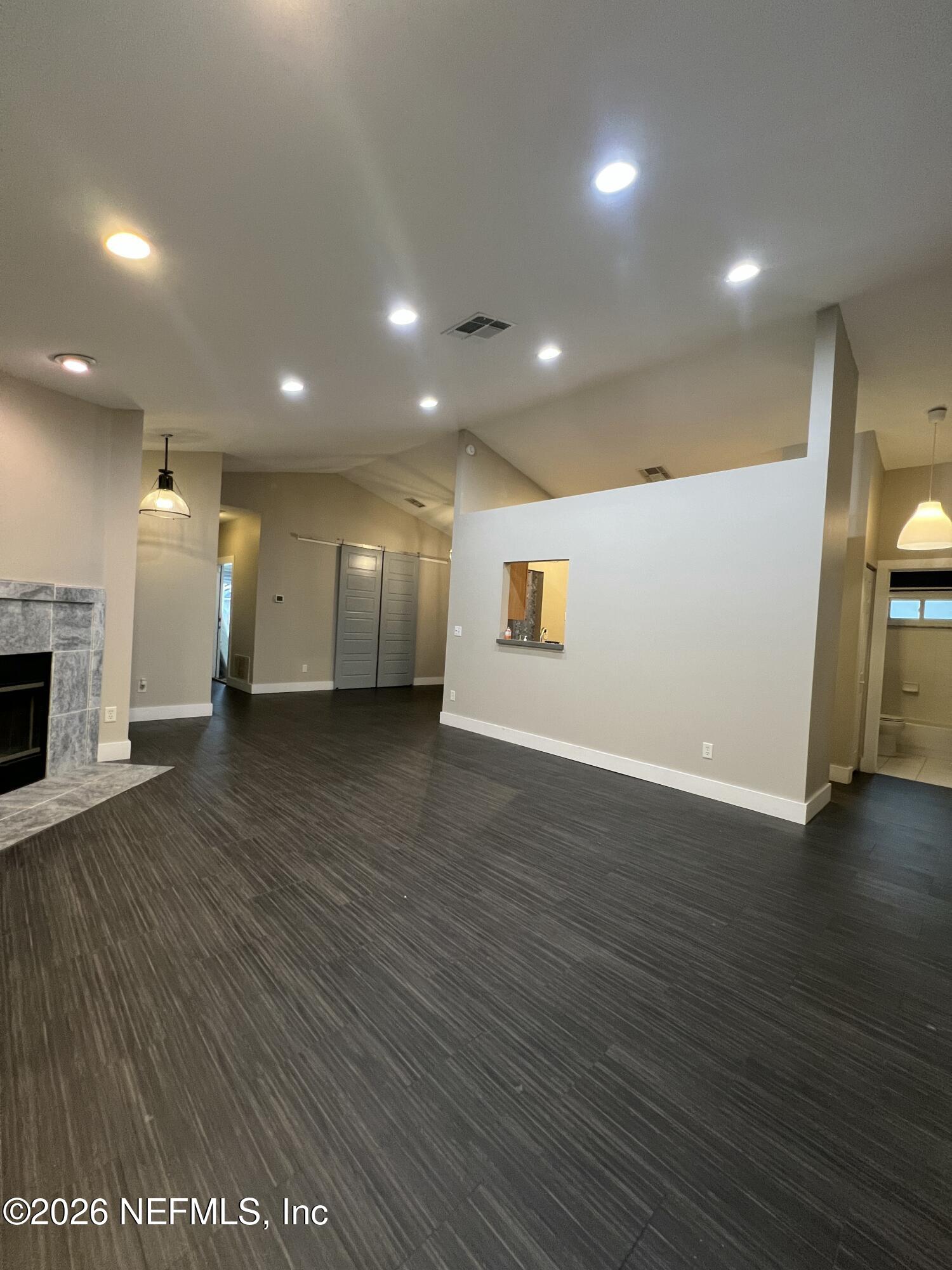 1115 Main Street Atlantic Beach, FL 32233 - Photo 2 of 14 an empty room with wooden floor and fireplace