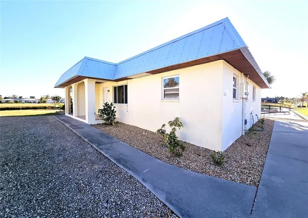a view of a house with backyard and sitting area