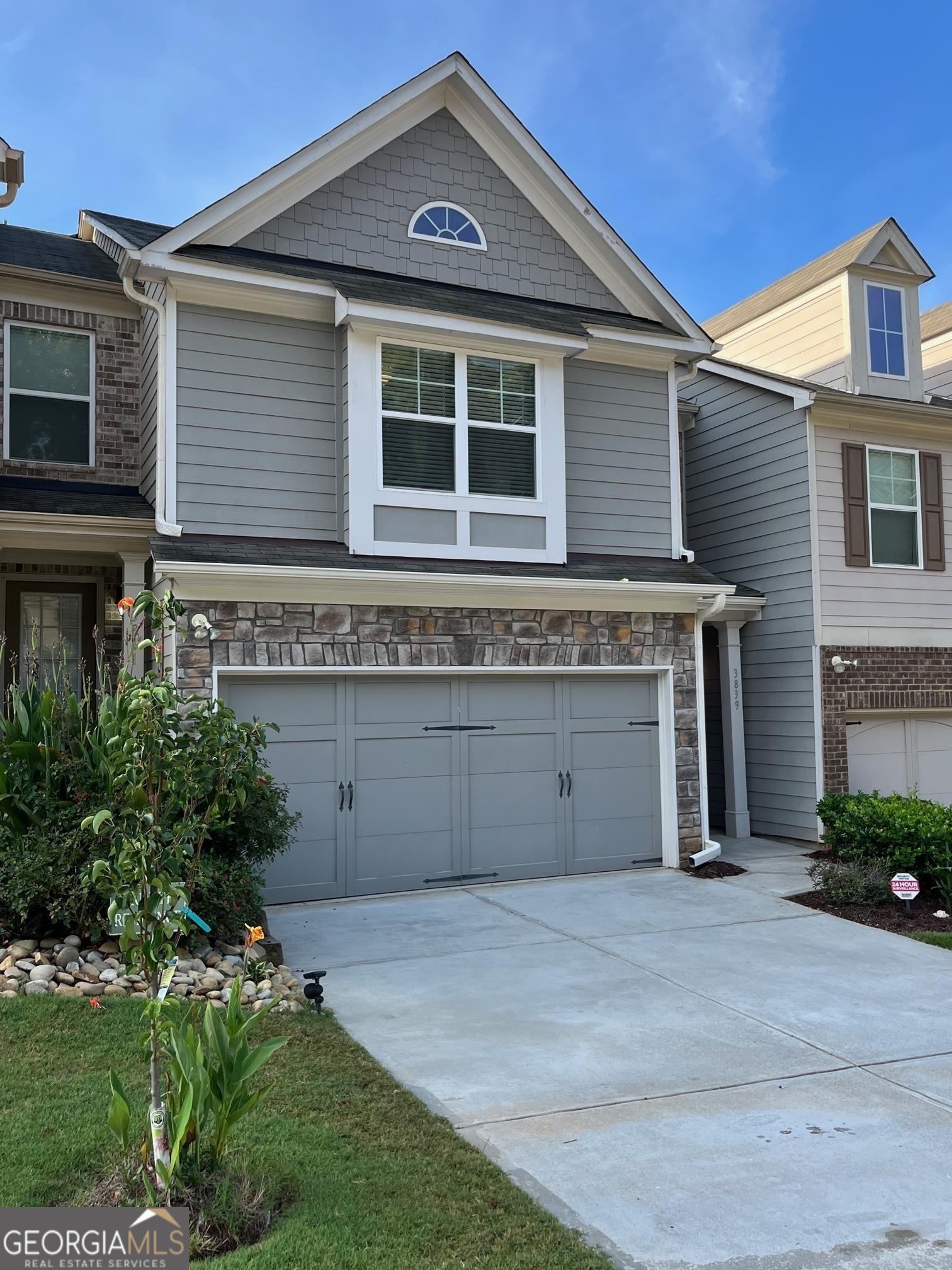 a front view of a house with a garden and garage