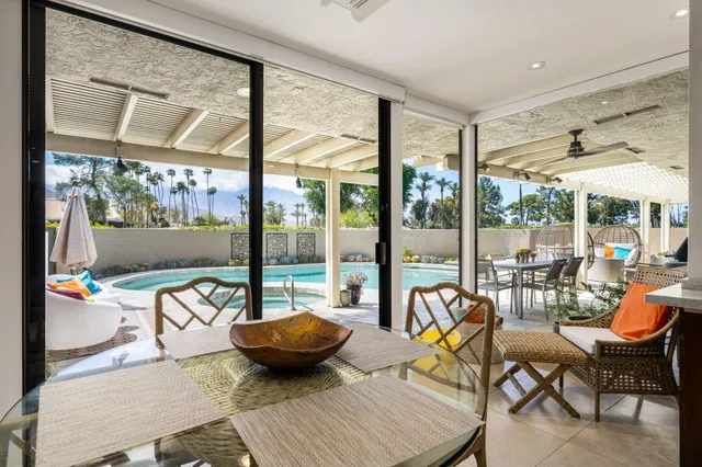a view of a dining room with furniture a chandelier and wooden floor