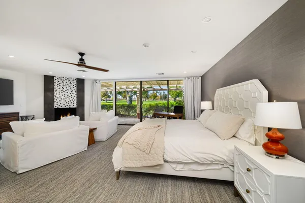 a bedroom with a bed and a large window