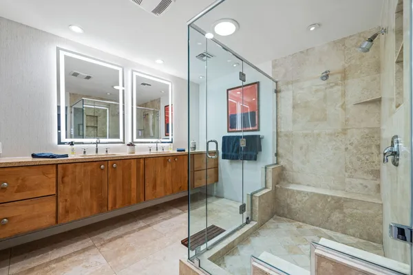 a bathroom with double vanity and a shower