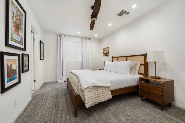 a bedroom with a bed wooden floors and a chandelier
