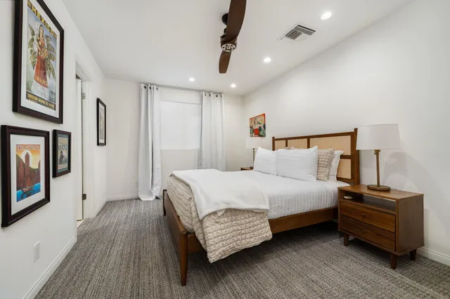 a bedroom with a bed wooden floors and a chandelier