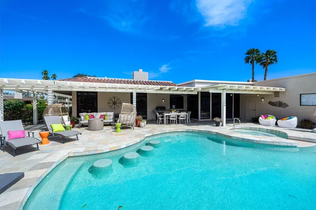 a view of a house with swimming pool and sitting area