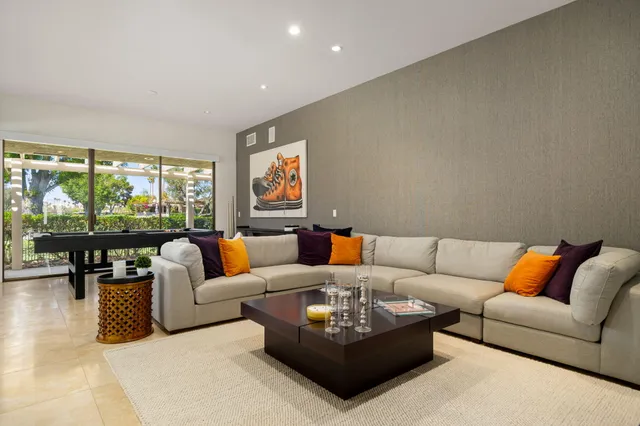 a living room with furniture and a floor to ceiling window