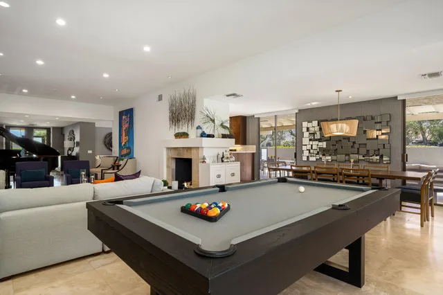 a living room with fireplace furniture and kitchen view