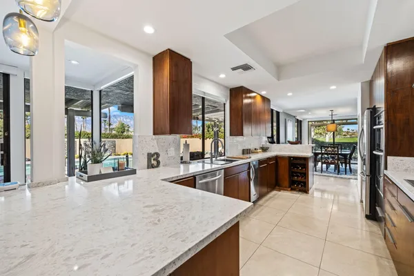 a kitchen with stainless steel appliances granite countertop sink stove and refrigerator