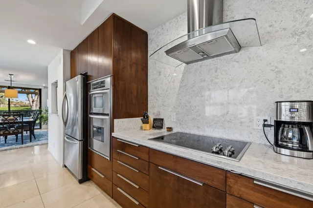 a kitchen with stainless steel appliances granite countertop a refrigerator and a sink