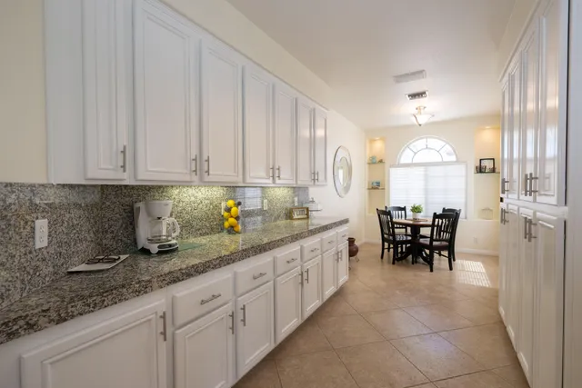 a kitchen with sink cabinets and dining table chair