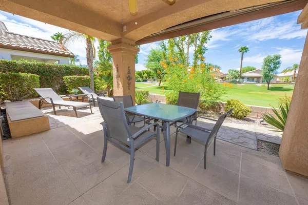 a view of a patio with a table chairs and a backyard