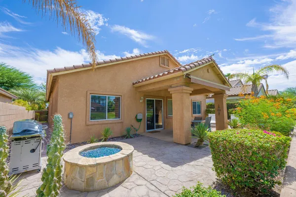 a view of a house with a backyard and sitting area