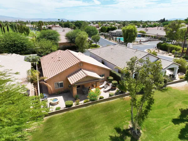 an aerial view of a house with a garden and lake view