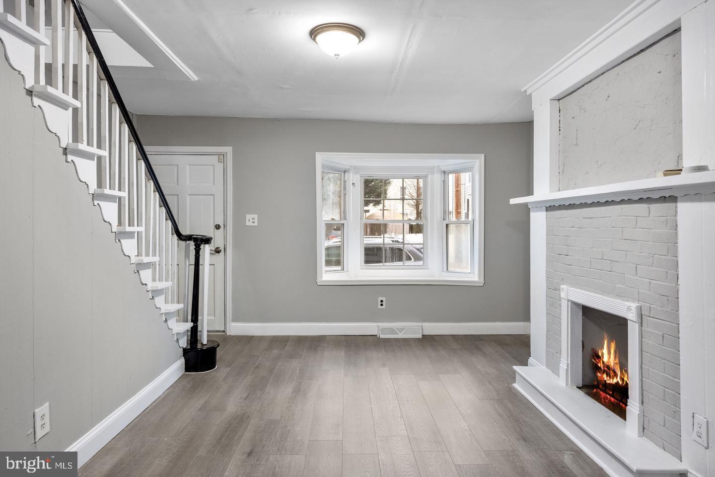244 Cedar Street Bristol, PA 19007 - Photo 4 of 18 wooden floor fireplace and windows in an empty room