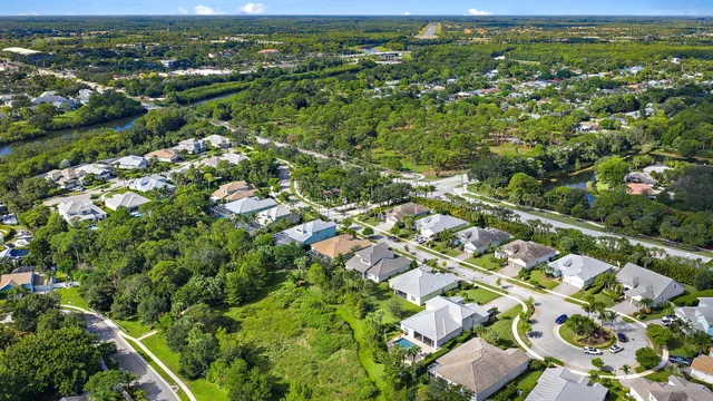 an aerial view of residential houses with outdoor space and trees