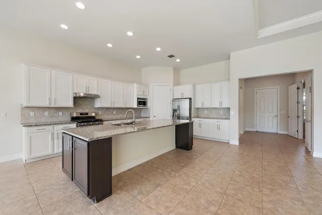 a kitchen with a stove top oven and white cabinets
