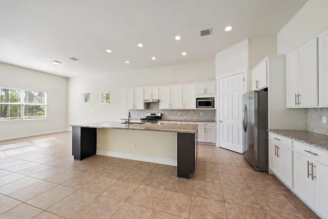 a kitchen with stainless steel appliances granite countertop a refrigerator sink and cabinets