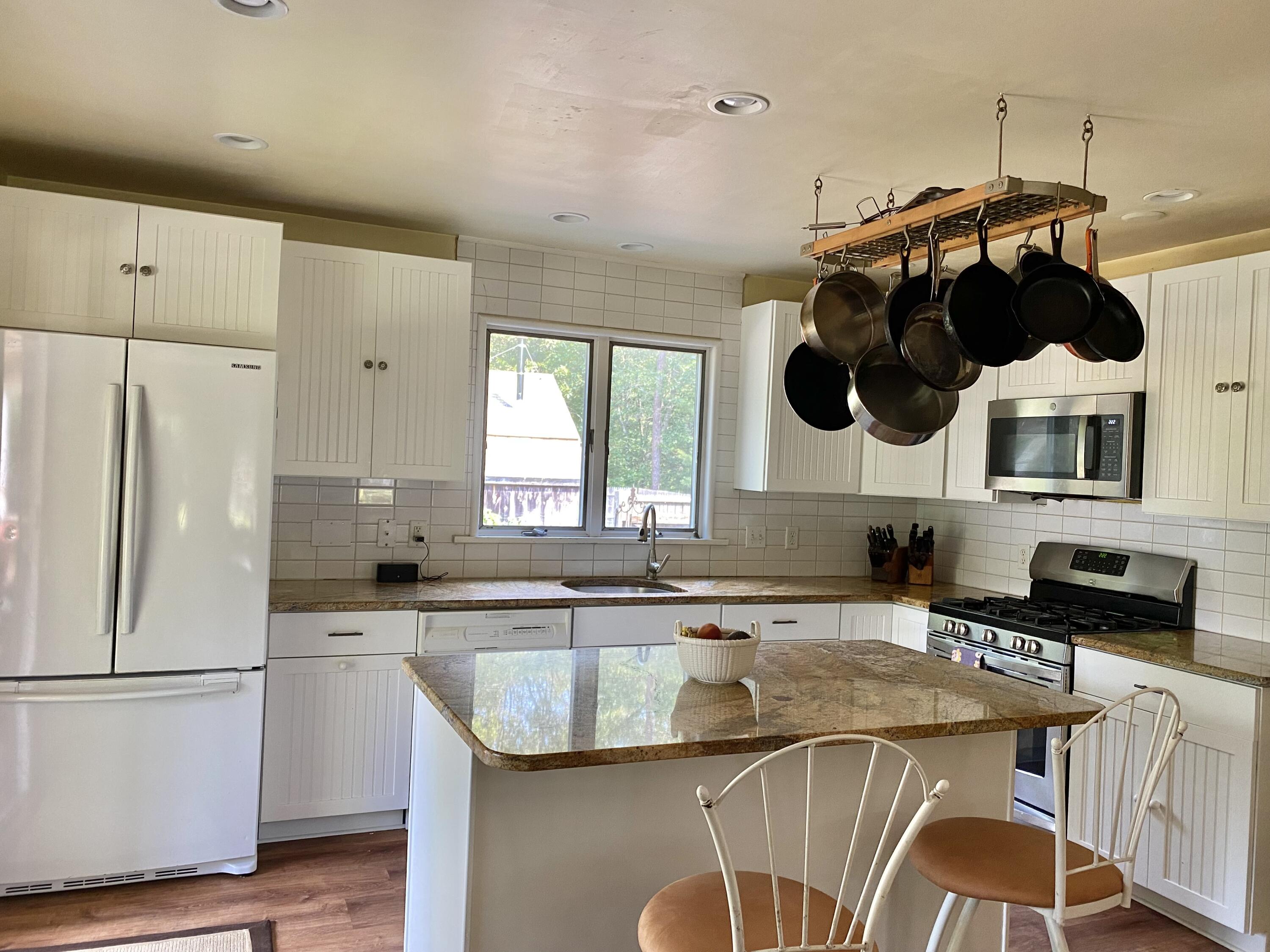 190 Little River Road Cotuit, MA 02635 - Photo 5 of 23 a kitchen with stainless steel appliances granite countertop a sink a stove a refrigerator a washer and dryer with wooden floor