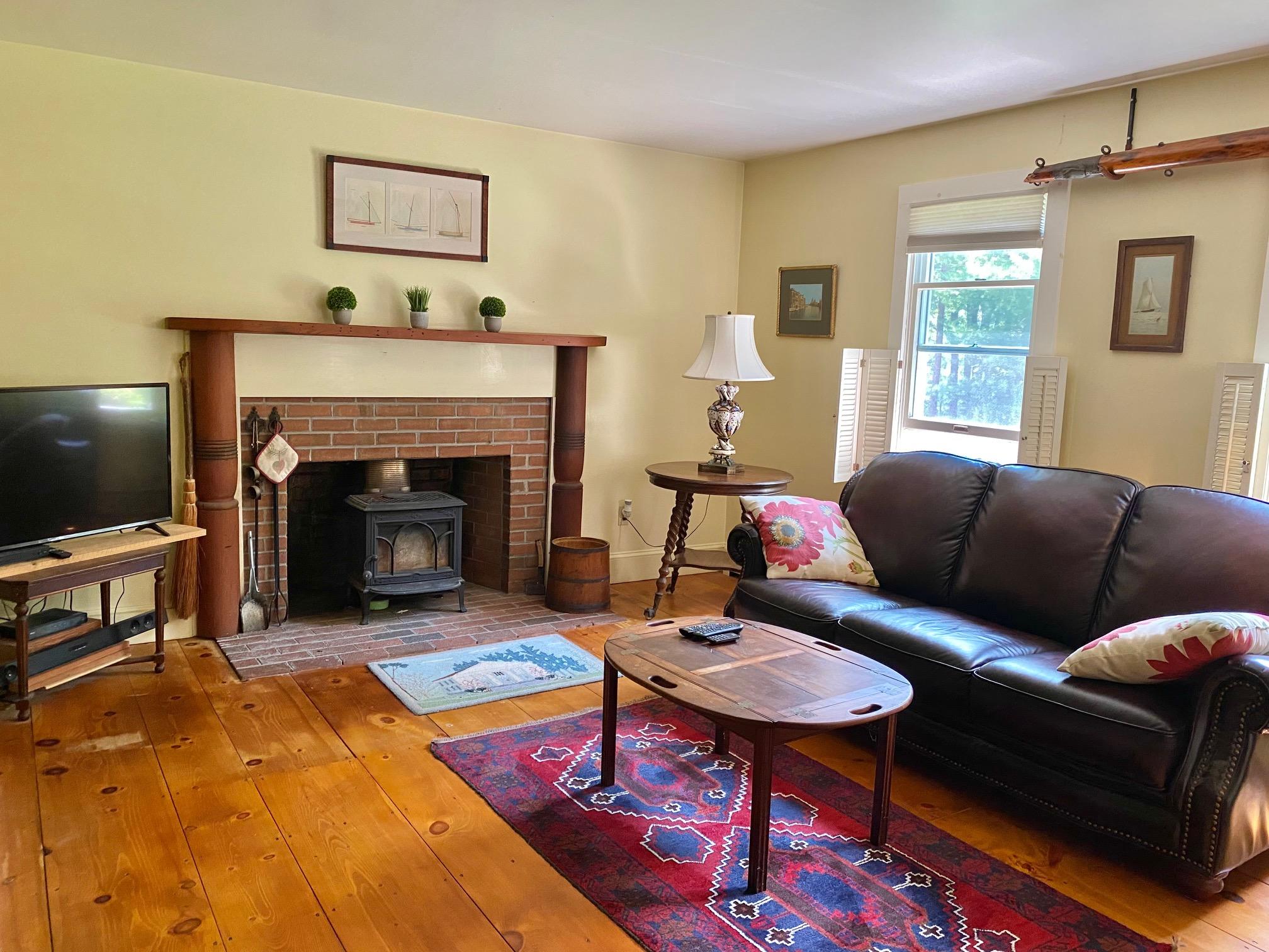 190 Little River Road Cotuit, MA 02635 - Photo 8 of 23 a living room with furniture a flat screen tv and a fireplace