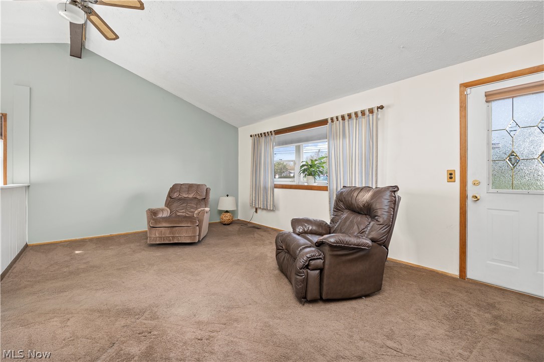 5697 Jaycox Road North Ridgeville, OH 44039 - Photo 5 of 28 living room featuring lofted ceiling with beams, ceiling fan, and carpet floors
