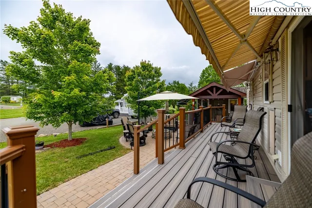 a view of a patio with a table and chairs under an umbrella with a garden